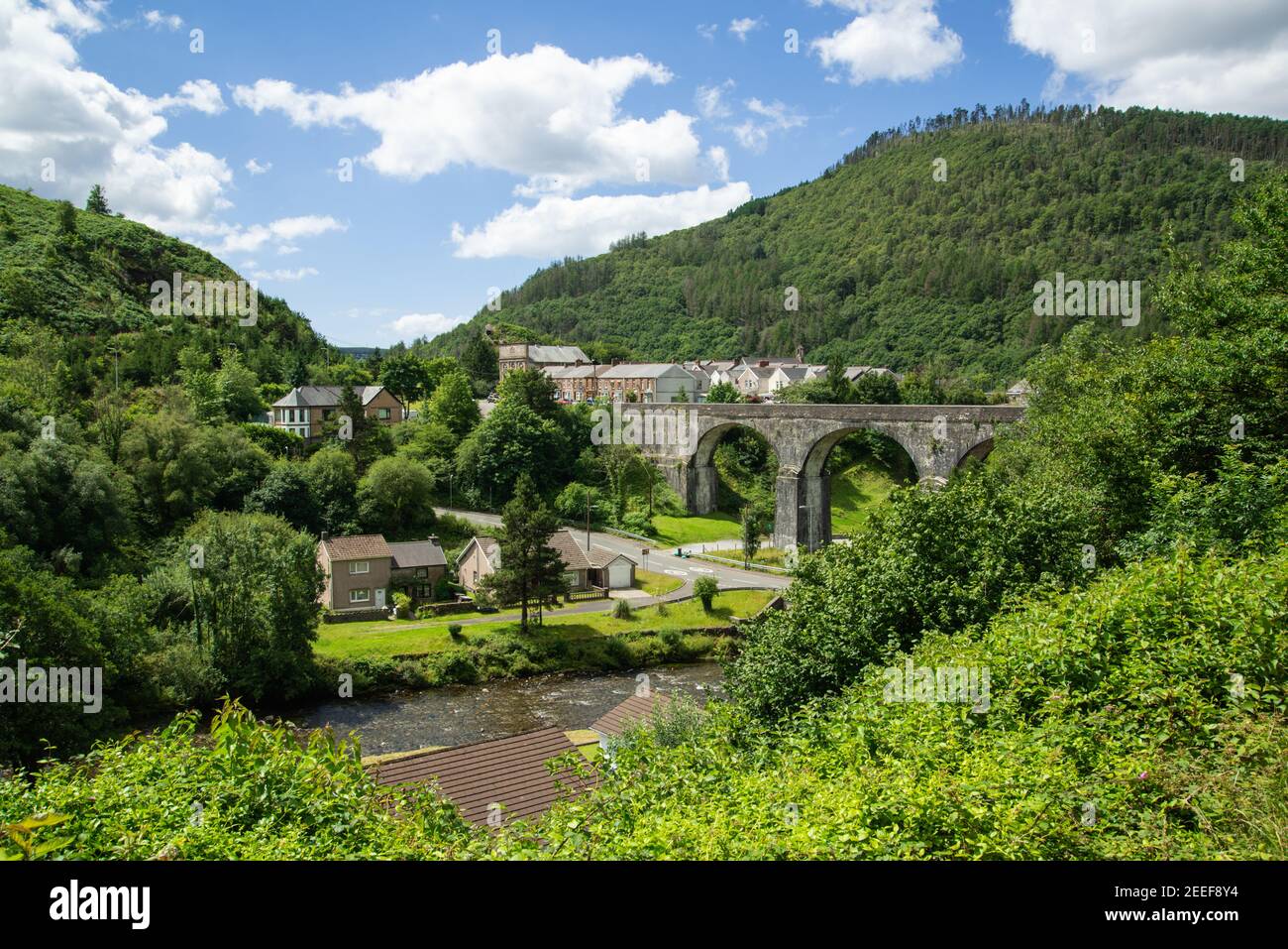 Ancien aqueduc traversant une vallée fluviale et un village Banque D'Images