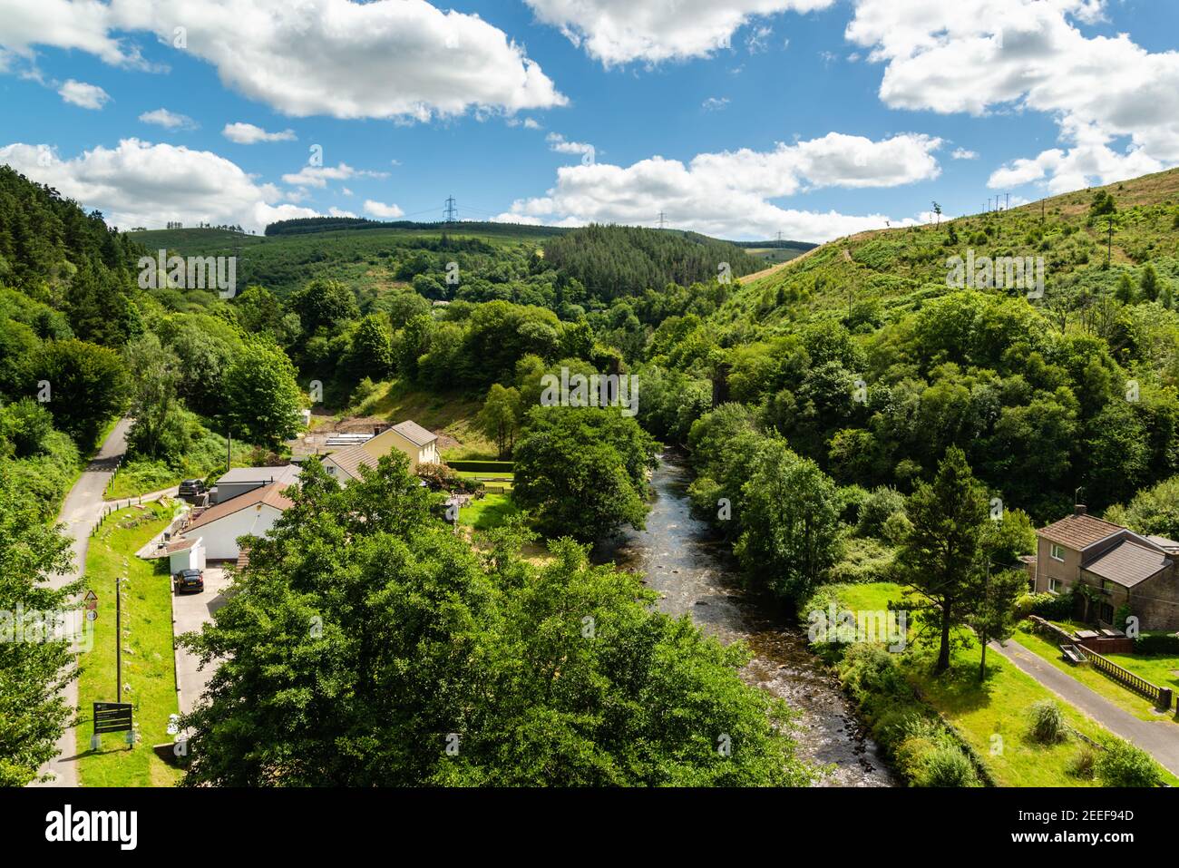 Vue sur une rivière et un village, avec des collines environnantes Banque D'Images