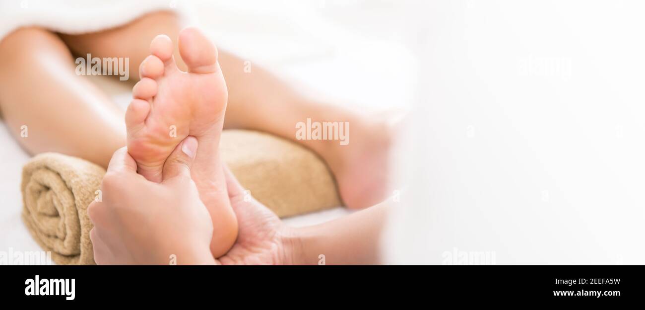 Thérapeute professionnel donnant un massage thaïlandais traditionnel des pieds à une femme dans le spa Banque D'Images