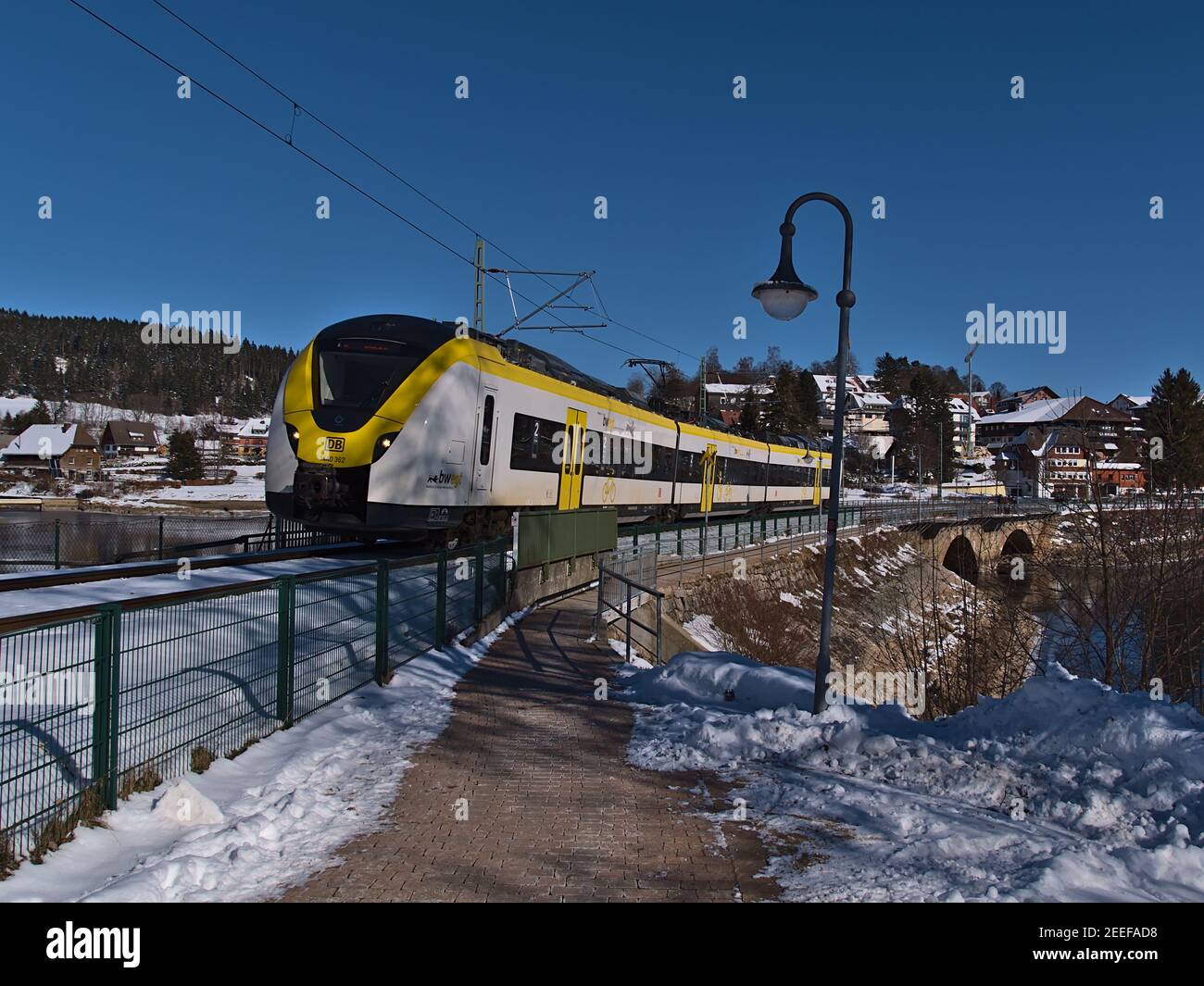 Train de banlieue blanc et jaune exploité par Deutsche Bahn après avoir traversé le pont ferroviaire de Schluchsee, qui fait partie du train Dreiseenbahn. Banque D'Images