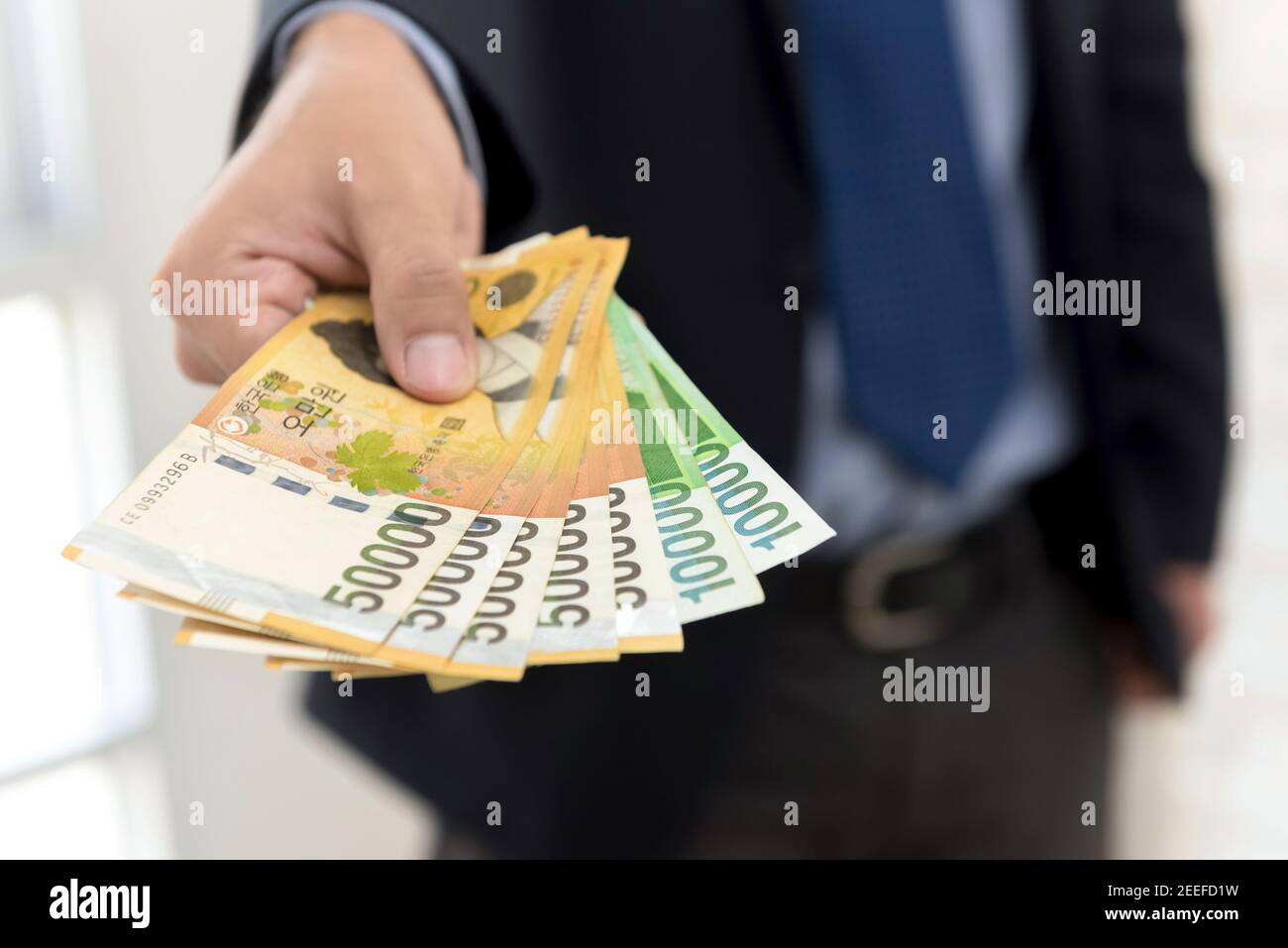 Homme d'affaires donnant de l'argent, la Corée du Sud a gagné des billets Banque D'Images