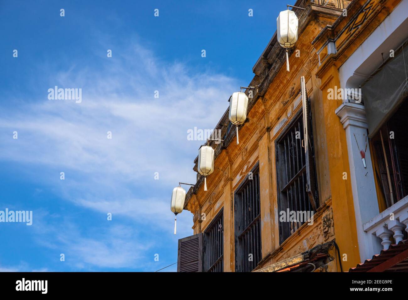 Ancien bâtiment avec lanternes chinoises, détail de l'architecture du Vietnam. Façade de maison jaune. Maison coloniale française à Hoi une ville historique. Visite vietnamienne Banque D'Images