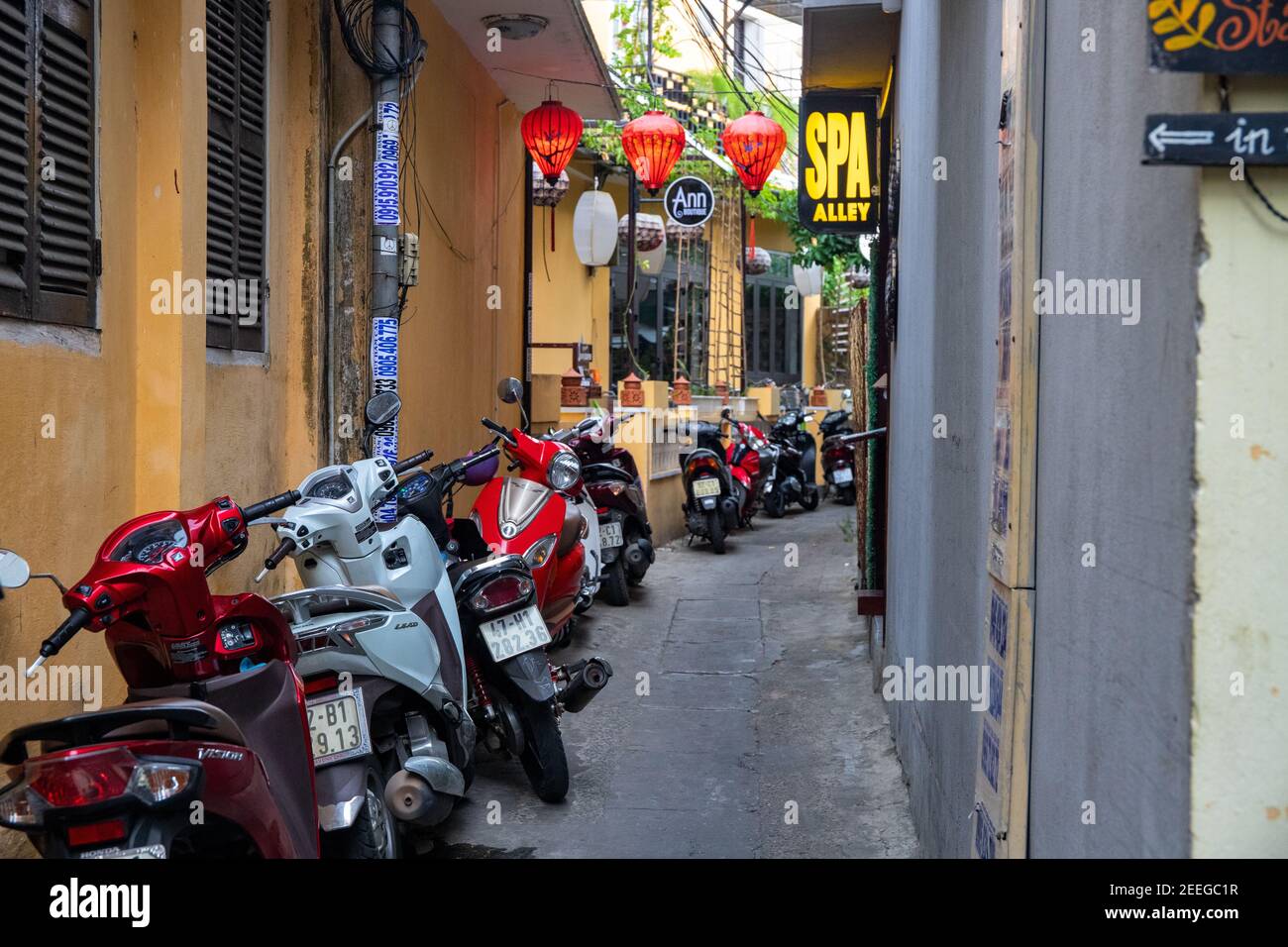 Hoi an, Vietnam - 26 juillet 2019 : vue sur la rue de la vieille ville avec maisons jaunes et attractions touristiques. Parking motos dans une rue étroite. Populaire tr asiatique Banque D'Images