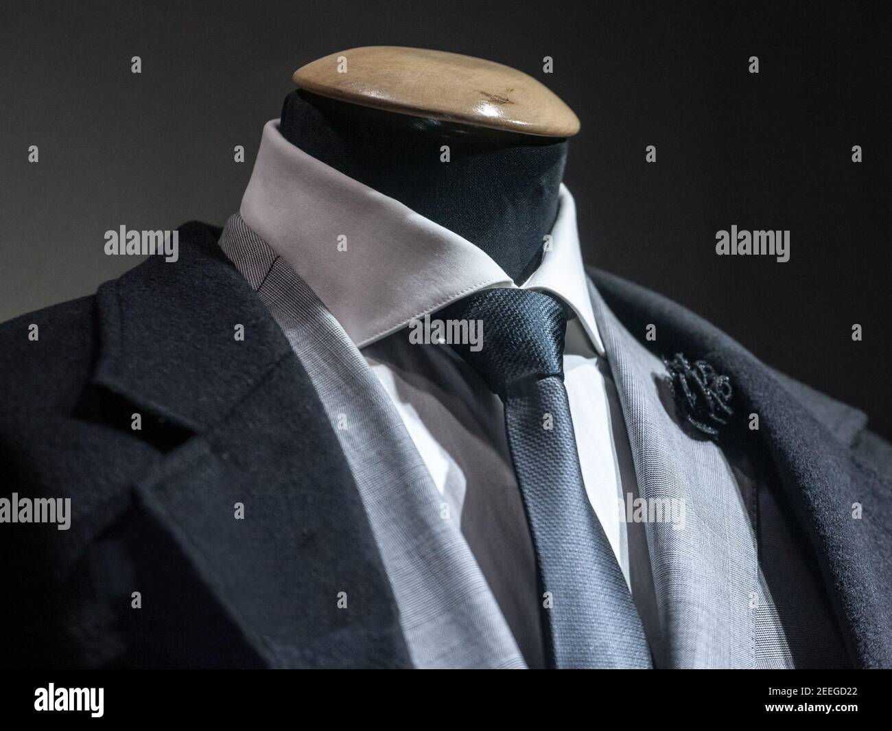 Costume habillé pour hommes, avec une chemise blanche, une cravate noire,  une épinglette noire et une veste grise sur maquette devant un magasin sur  mesure, sur un wi Photo Stock - Alamy