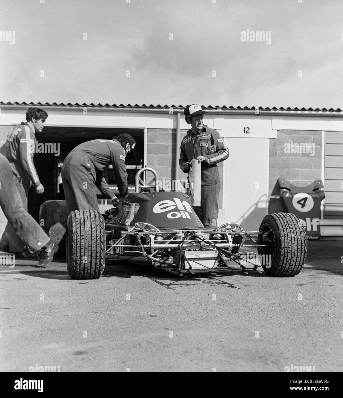 La voiture de course Elf Depailler est en cours de travail par des mécaniciens à l'extérieur du garage à Silverstone, 1975 Banque D'Images La voiture de course Elf Depailler est en cours de travail par des mécaniciens à l'extérieur du garage à Silverstone, 1975 Banque D'Images