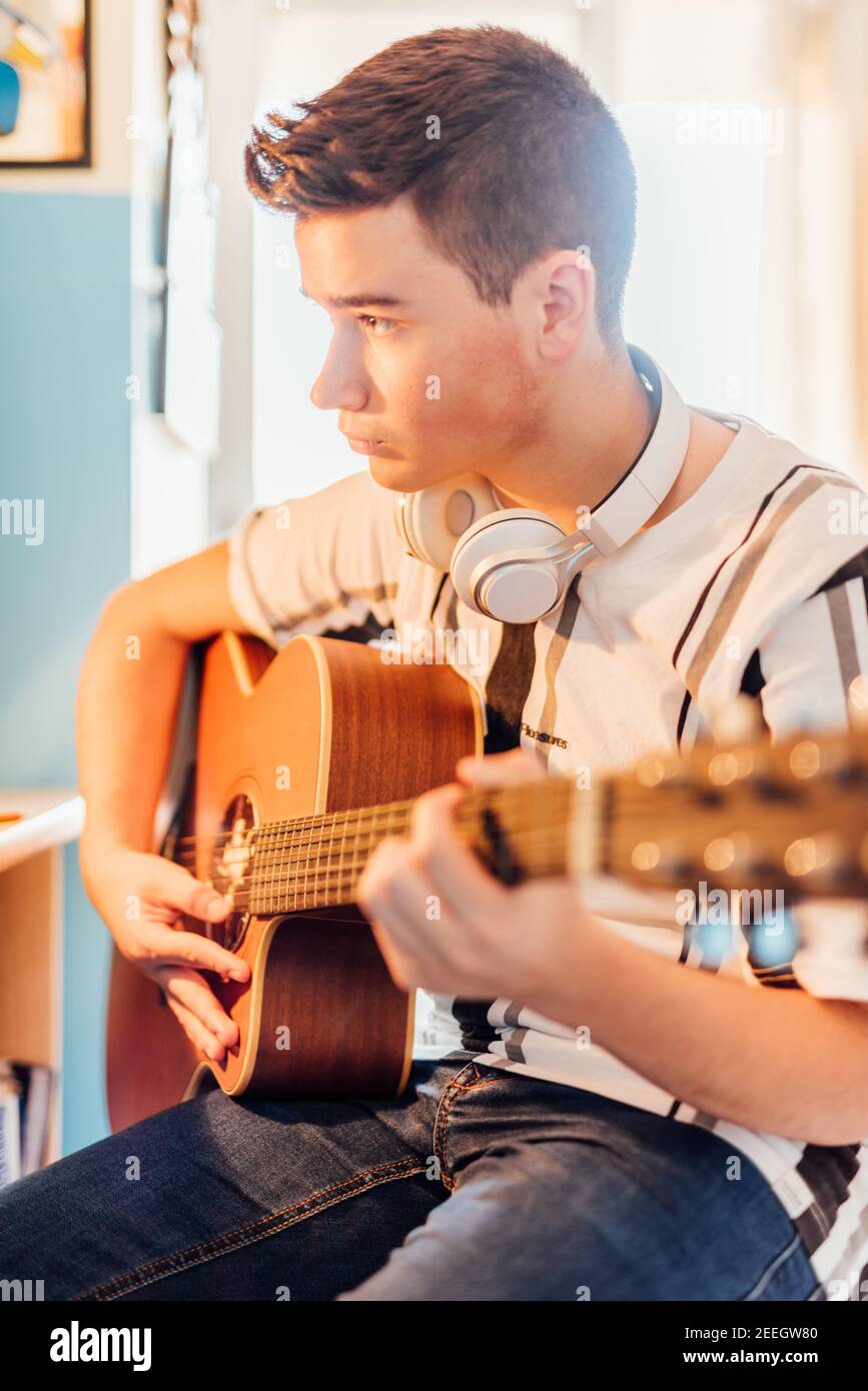 Eenage garçon prenant des leçons de guitare en ligne dans votre chambre. Concept de technologie. Banque D'Images