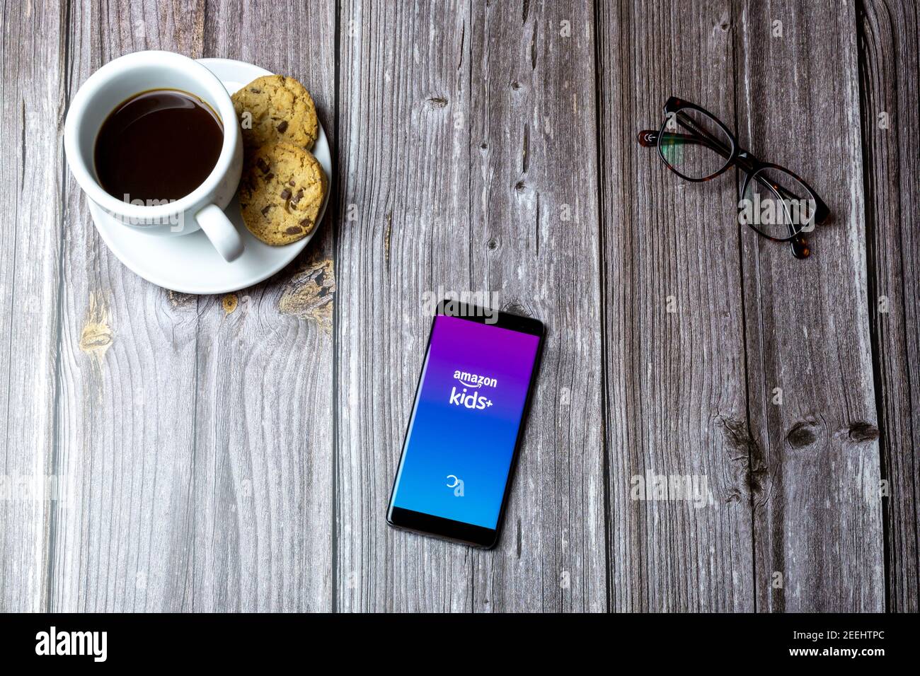 Un téléphone portable ou mobile posé sur un bois Table avec l'application Amazon Kids plus ouverte à l'écran Banque D'Images