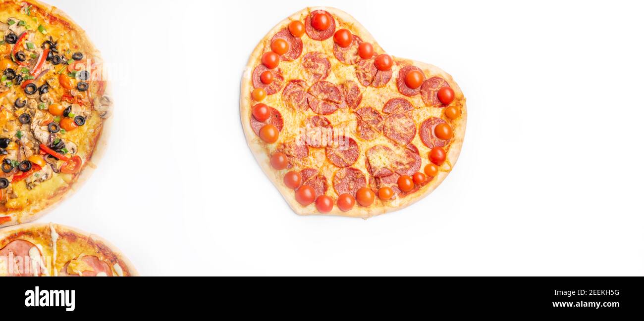 trois différentes sortes de pizzas, autour et coeur en forme de fond blanc avec espace de copie, salami, champignons, tomaton, pepperoni, tomates cerises et Banque D'Images