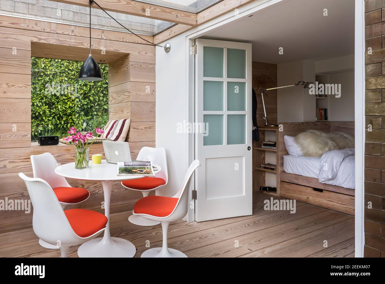 Studio jardin avec Eero Saarinen Tulip table et chaises, murs, sol et lit à Douglas Fir by Dominic Ash Banque D'Images