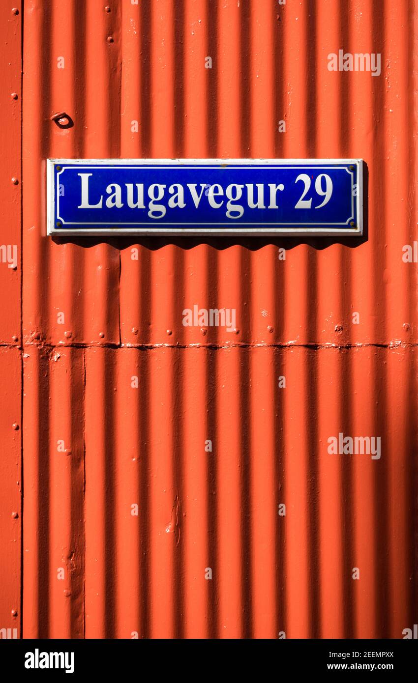 Panneau lumineux de tôle de fer ondulée peinte en rouge montrant le Crêtes avec un panneau de rue islandais bleu profond et blanc lettrage joint Banque D'Images
