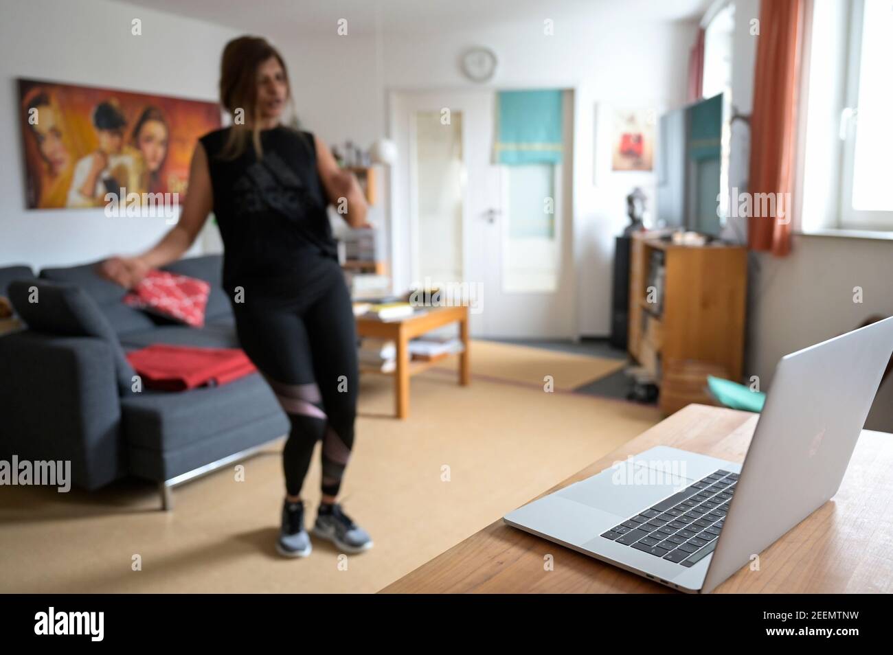 ALLEMAGNE, Hambourg, corona pandémie, jeune femme faisant du sport à la maison avec la diffusion en ligne de club de sport, Apple macbook écran avec Zumba danse session Banque D'Images