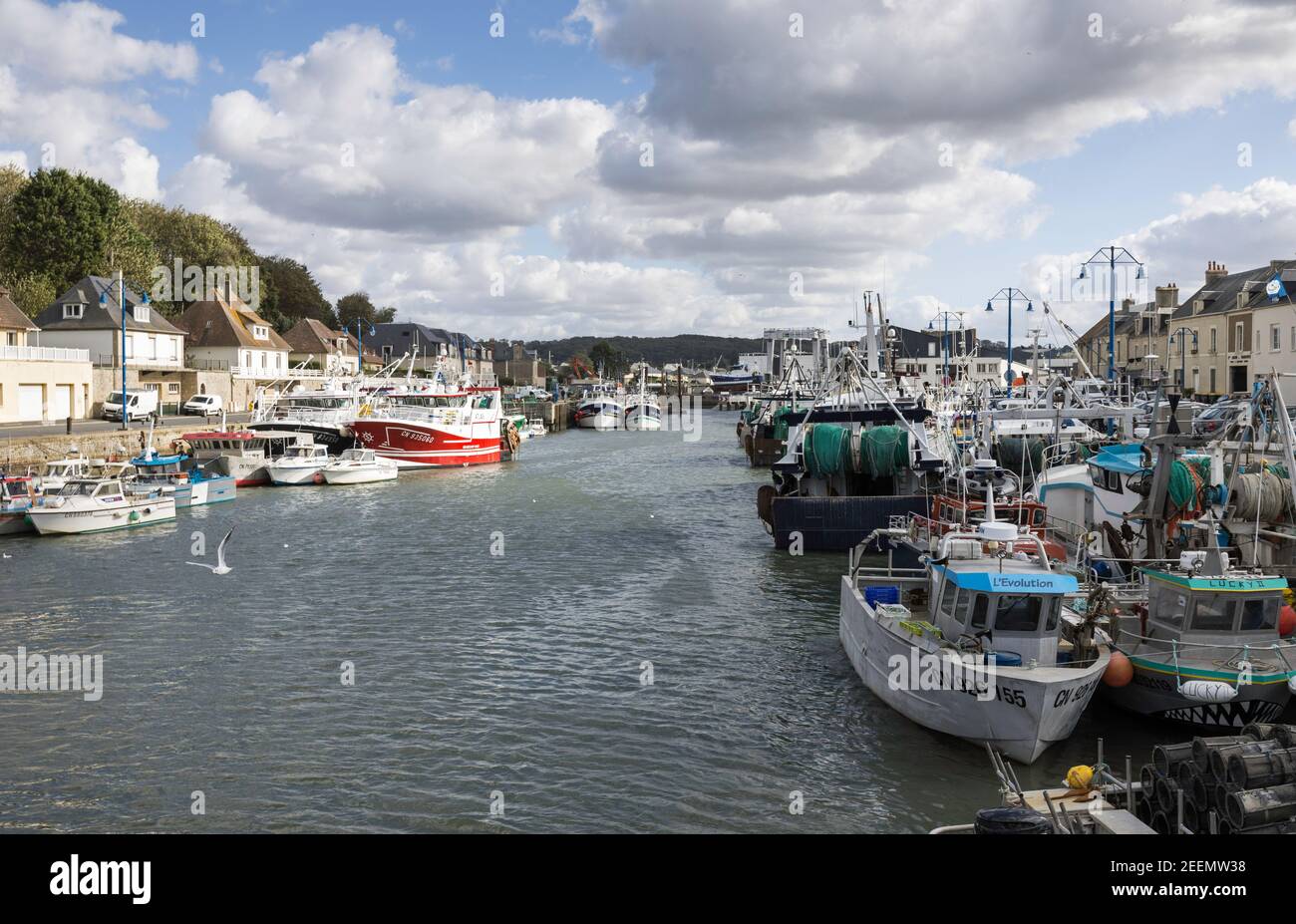 Bateaux de pêche et chalutiers amarrés côte à côte le long des deux côtés du quai de Port-en-Bessin, en Normandie, prêts à faire mer dans la Manche Banque D'Images