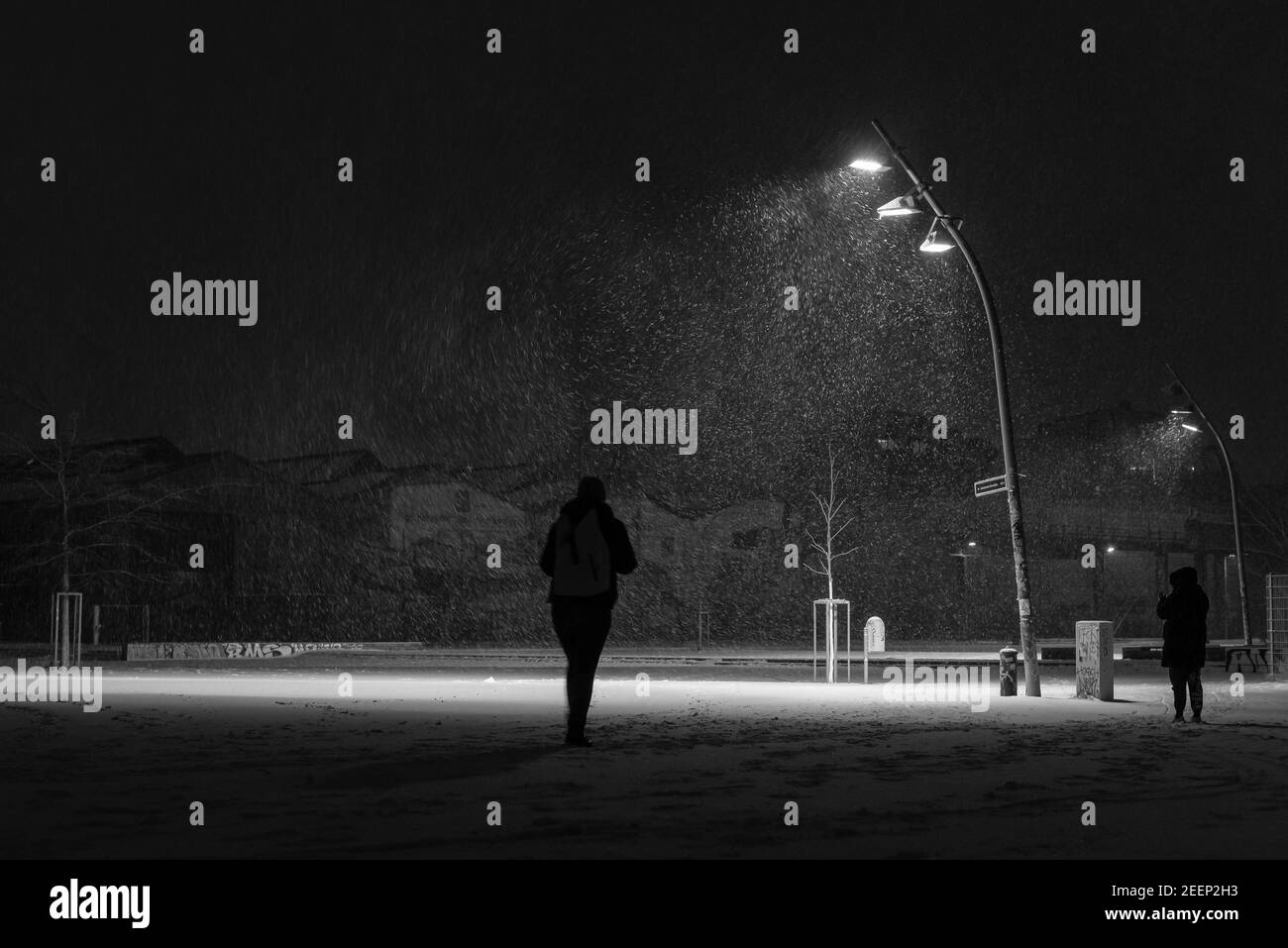 Neige flurys sur une place le soir, lumières de rue et neige flurys, il neige dans la soirée sur une grande place illuminée, une personne Banque D'Images