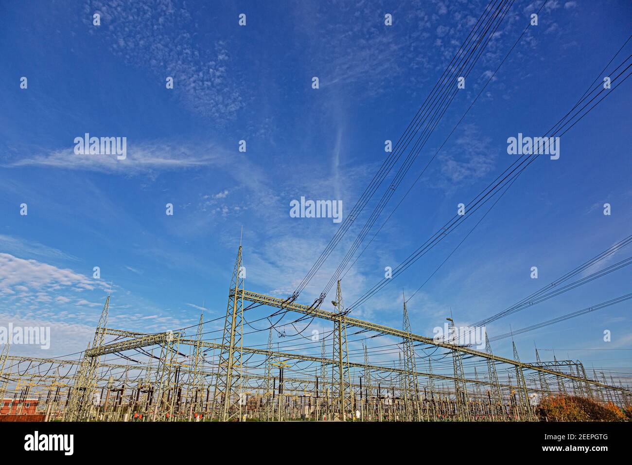 Illustration d'une station de transformateur avec de nombreux isolants et câbles pendant la journée en face d'un ciel bleu Banque D'Images