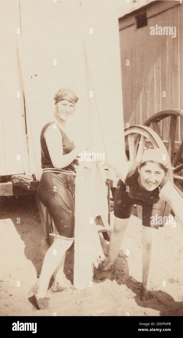 Vintage début du XXe siècle carte postale photographique montrant deux dames heureuses dans leurs costumes de bain devant les machines de bain. Banque D'Images