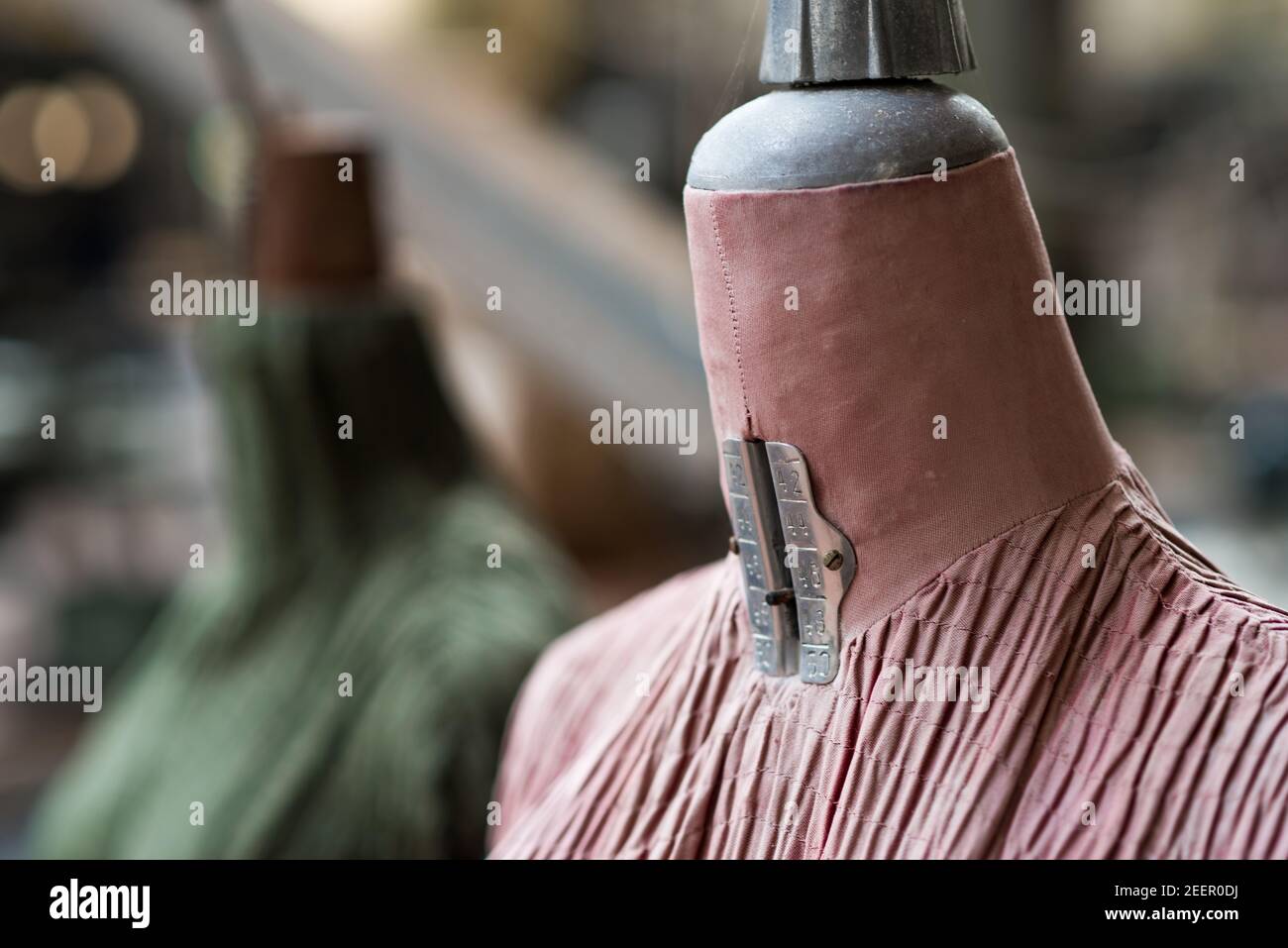 Gros plan sur les mannequins d'un tailleur rose et vert délavé Dans une ancienne et abandonnée usine de textile italienne Banque D'Images