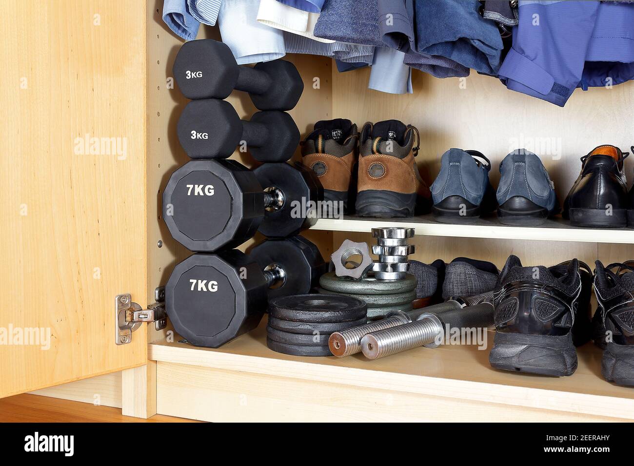 Équipement sportif intérieur et extérieur pour la pandémie de covid : poids, haltères, chaussures de course à pied et chaussures de randonnée au bas d'une garde-robe Banque D'Images