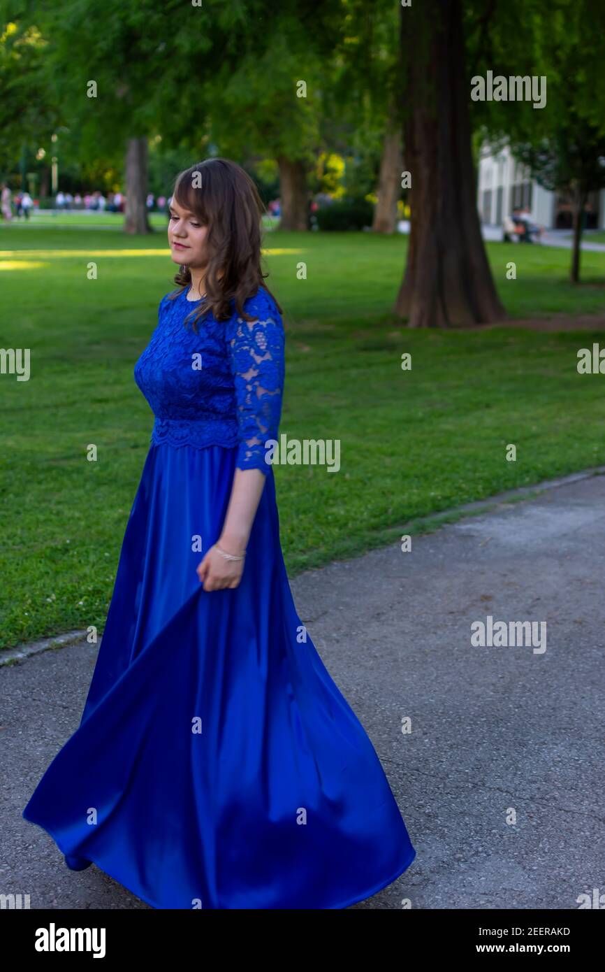 PROM fille tournant dans une robe bleue moderne et élégante. Tenue adorable et tendance. Belle photo de la nature pour la cérémonie de remise des diplômes Banque D'Images