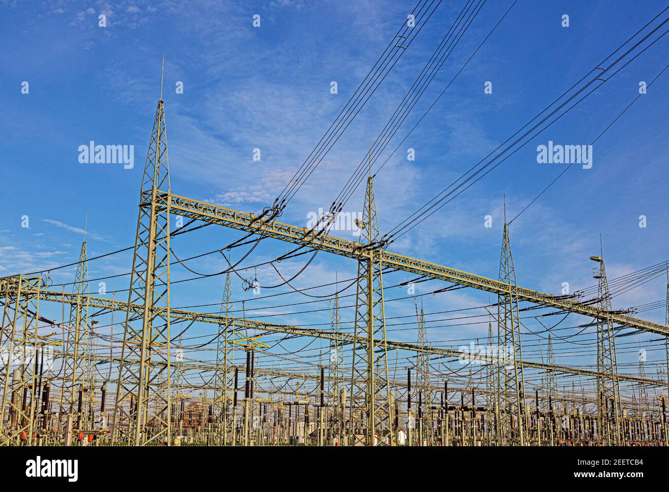 Illustration d'une station de transformateur avec de nombreux isolants et câbles pendant la journée en face d'un ciel bleu Banque D'Images