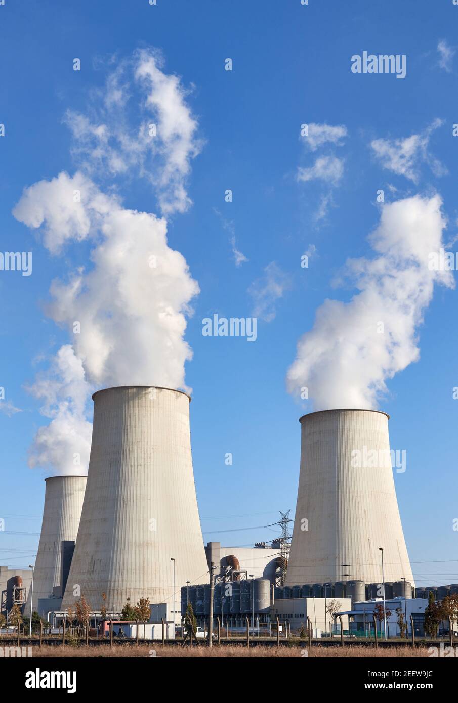 Centrale électrique avec cheminées de fumée contre le ciel bleu. Banque D'Images