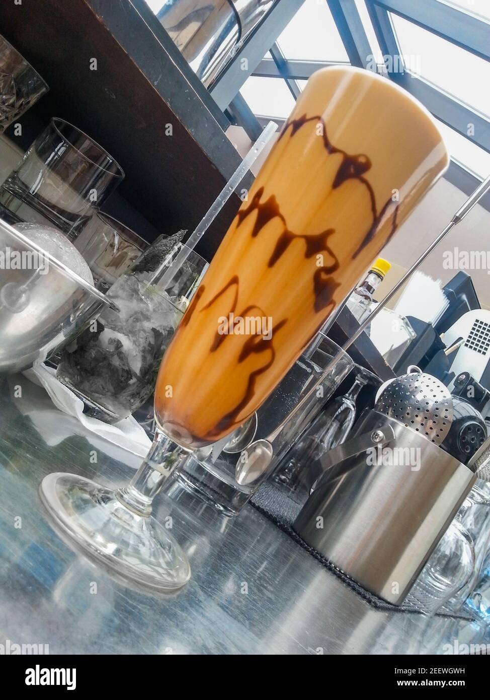 Café glacé en verre haut avec décoration chocolat derrière le bar Banque D'Images