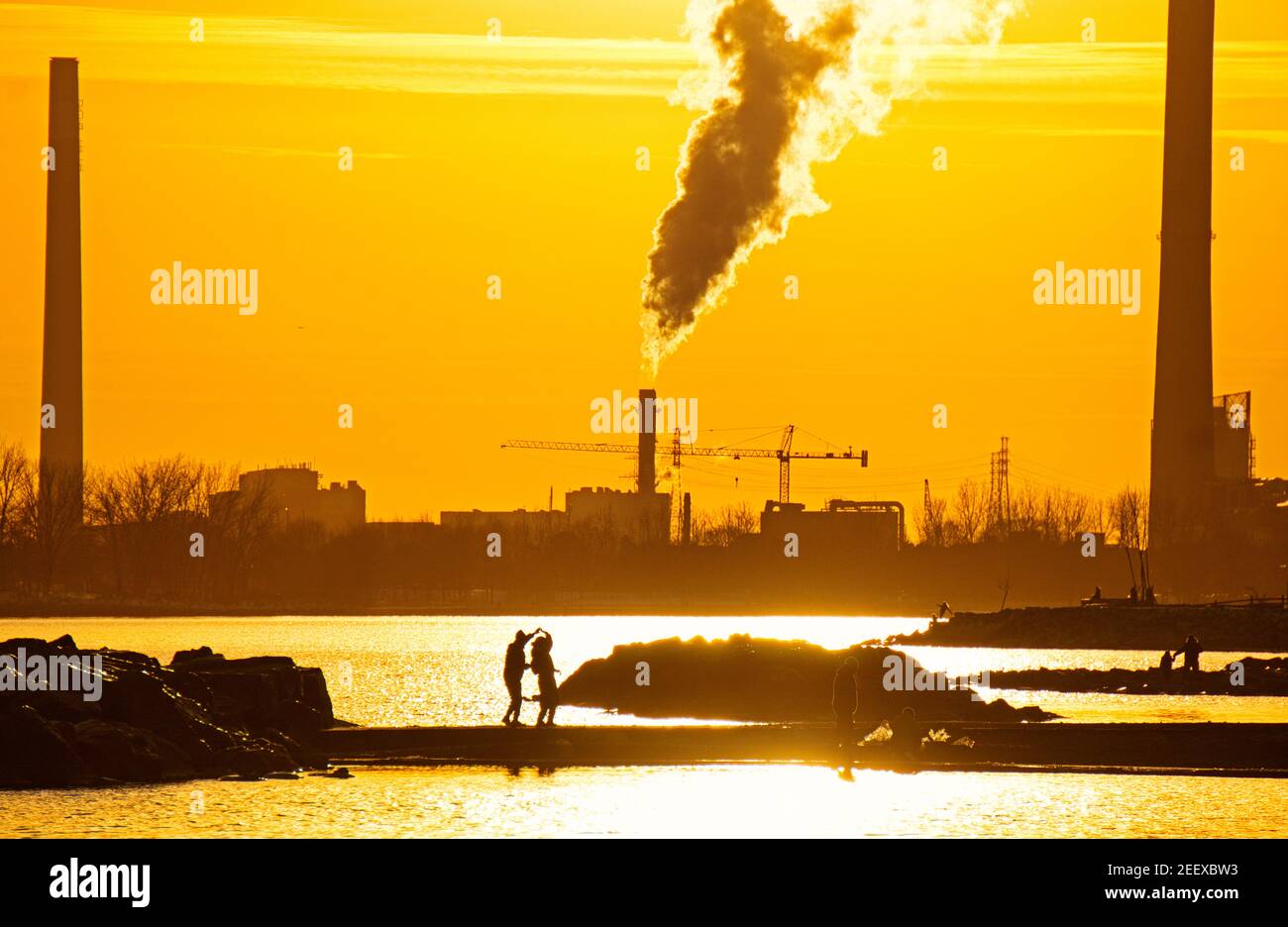 Silhouettes d'un couple dansant devant l'usine de traitement de l'eau de Ashbridge Bay au coucher du soleil pendant le confinement de Covid-19 dans les plages, Toronto (Ontario), C Banque D'Images