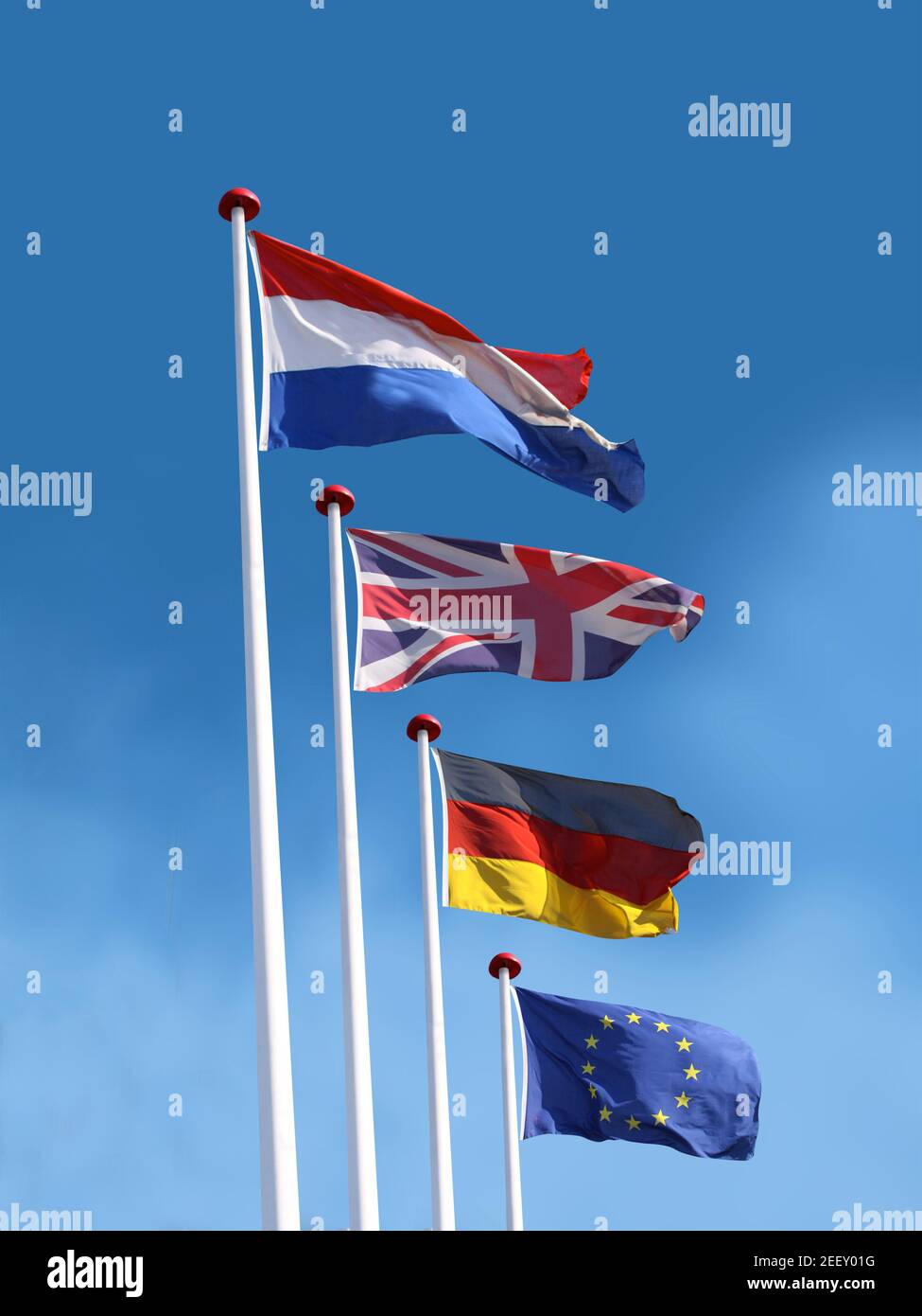 Drapeaux de la France, du Royaume-Uni, de l'Allemagne et de l'Union européenne sur les mâts. Le drapeau de la France est en haut. Fond bleu ciel. Banque D'Images