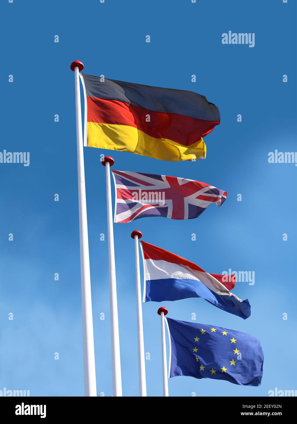 Drapeaux de l'Allemagne, du Royaume-Uni, de la France et de l'Union européenne sur les mâts. Le drapeau de l'Allemagne est en haut. Fond bleu ciel. Banque D'Images