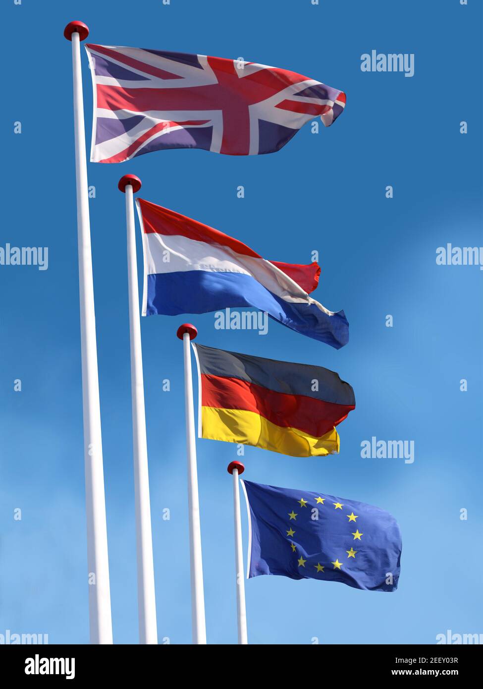 Drapeaux du Royaume-Uni, de la France, de l'Allemagne et de l'Union européenne sur les mâts de drapeaux. Le drapeau du Royaume-Uni est en haut. Fond bleu ciel. Banque D'Images