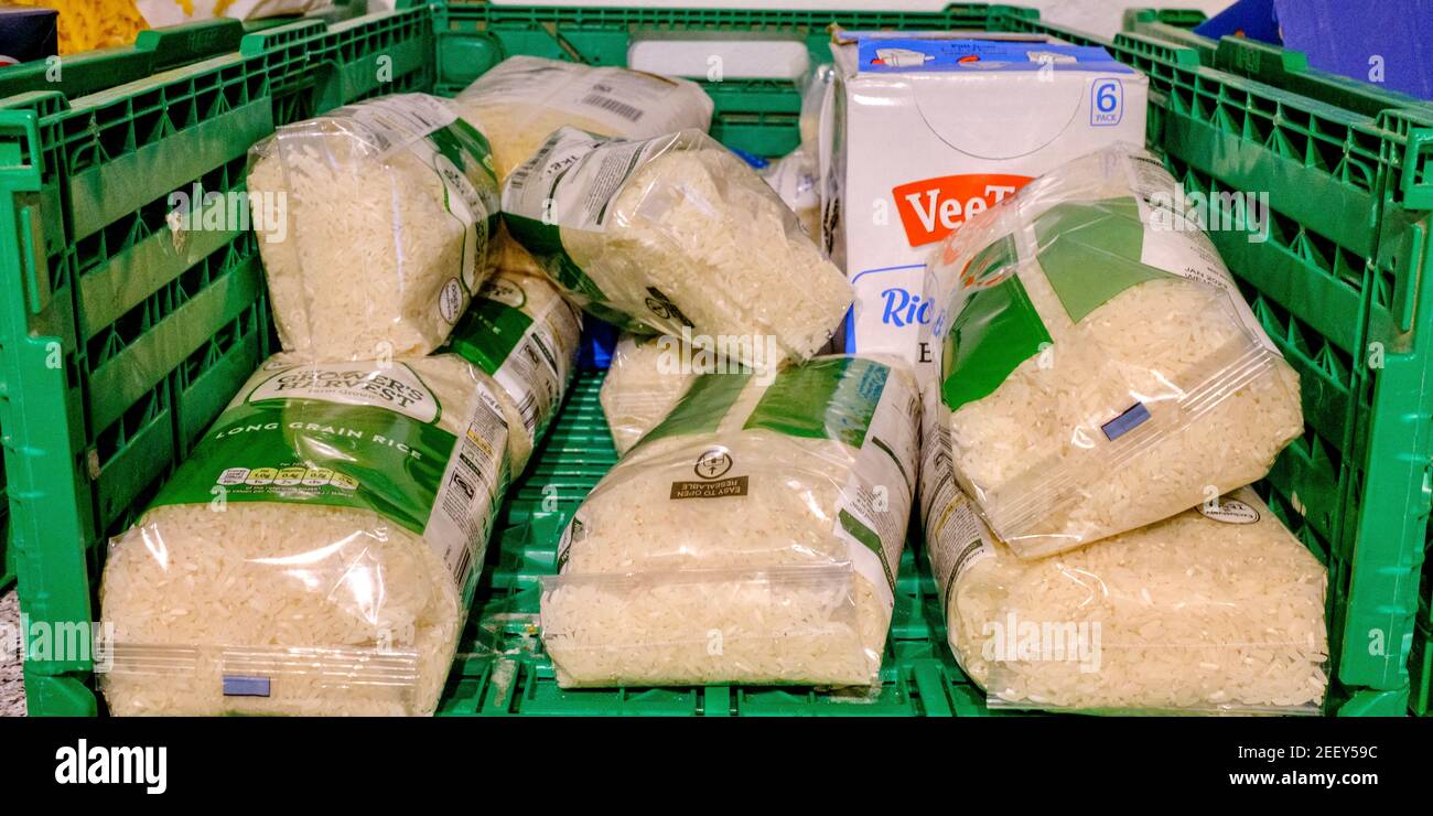 Caisse de paquets de riz dans le cadre de dons d'aliments séchés donnés à une banque alimentaire Trussell Trust. Riz dans un emballage en plastique. Banque D'Images