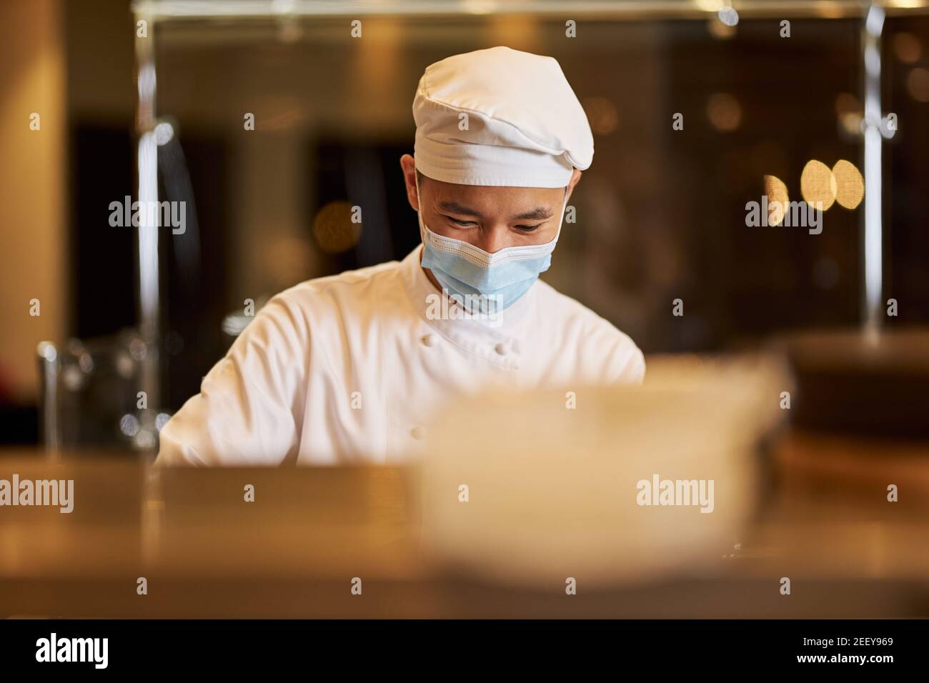 Le personnel de cuisine responsable utilise un équipement de protection personnel lors de l'intervention un restaurant Banque D'Images