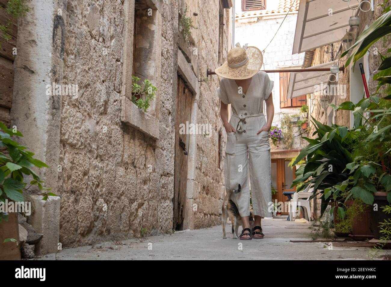 Vue arrière de la belle blonde jeune femme voyageur portant chapeau de paille de soleil de visite et de profiter des vacances d'été dans une vieille ville traditionnelle costal Banque D'Images