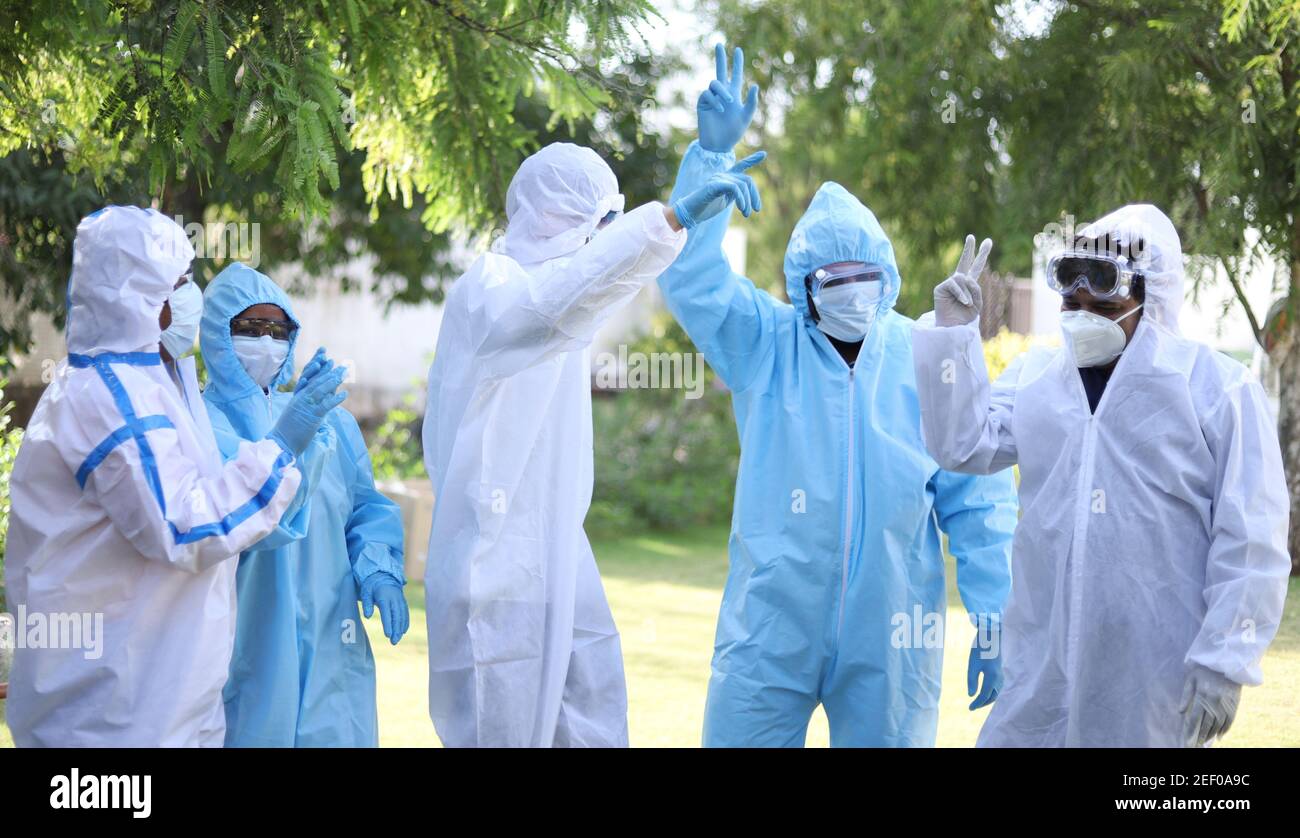 Groupe optimiste de travailleurs médicaux portant des vêtements de protection dansant heureusement Banque D'Images
