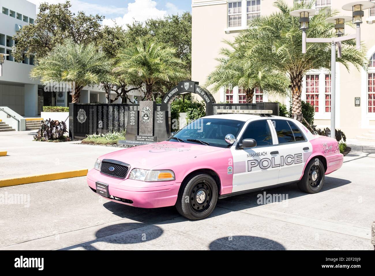 Une voiture de police désaffectée de Miami Beach peinte en rose à l'extérieur de l'ancien hôtel de ville avec le mémorial des policiers de Miami Beach en arrière-plan, à Miami Beach. Banque D'Images
