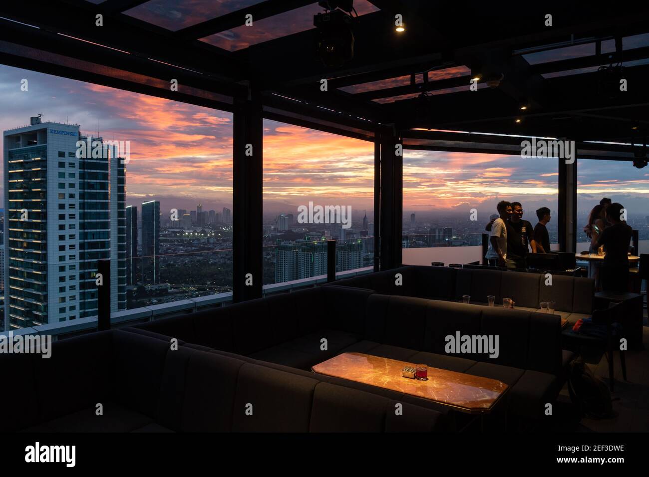 Jakarta, Indonésie - janvier 11 2020 : les gens prennent une photo d'un bar de luxe sur le toit surplombant les gratte-ciel du quartier des affaires de Jakarta au coucher du soleil à Indones Banque D'Images