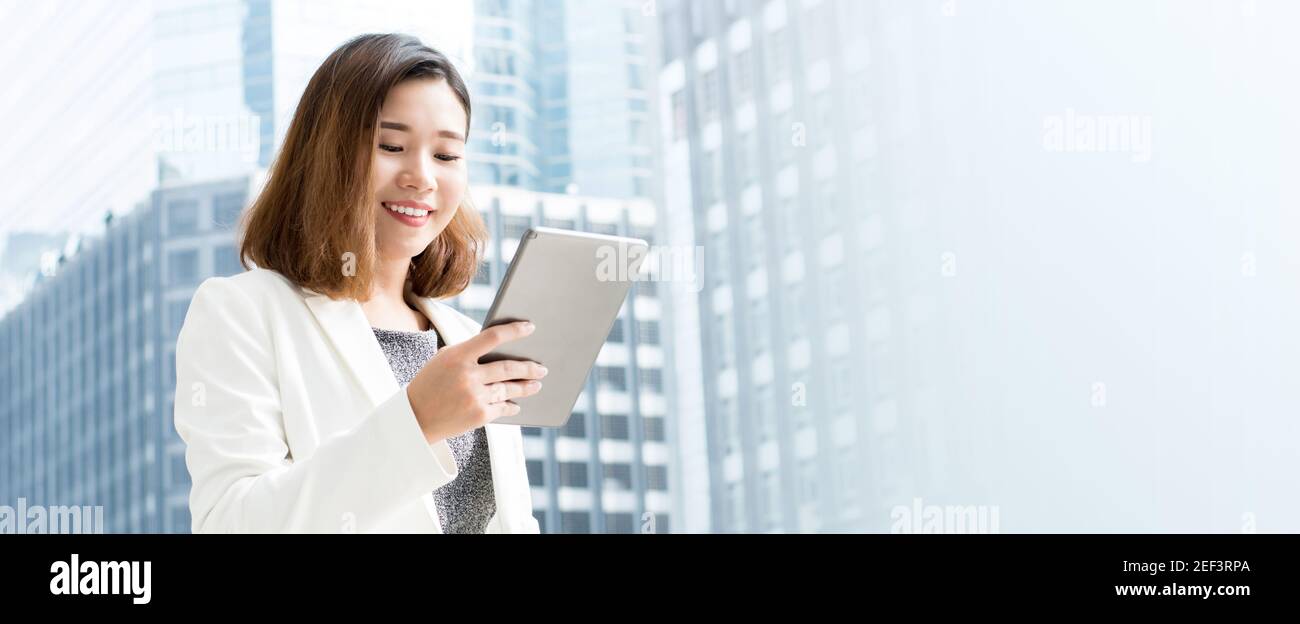 Femme d'affaires asiatique utilisant une tablette informatique dans la ville - bannière panoramique avec espace de copie Banque D'Images