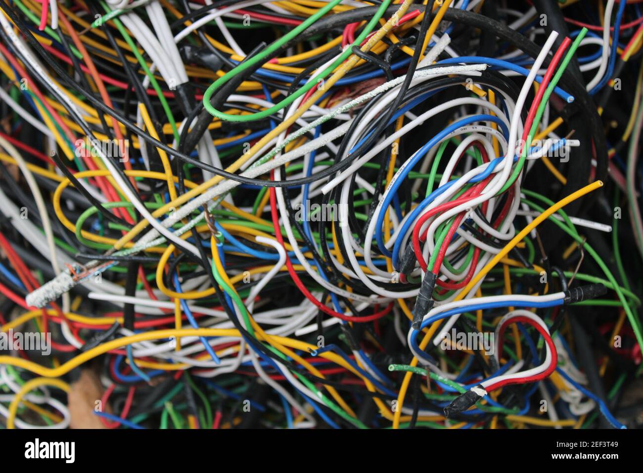 Fils et câbles multicolores enroulés dans un tas derrière un atelier d'électricien local Banque D'Images