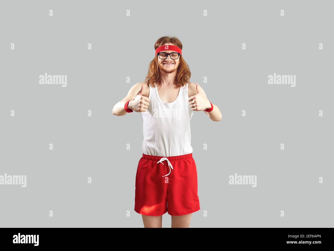 Drôle de sourire hipster rouge et blanc sportswear debout et je montre les pouces Banque D'Images