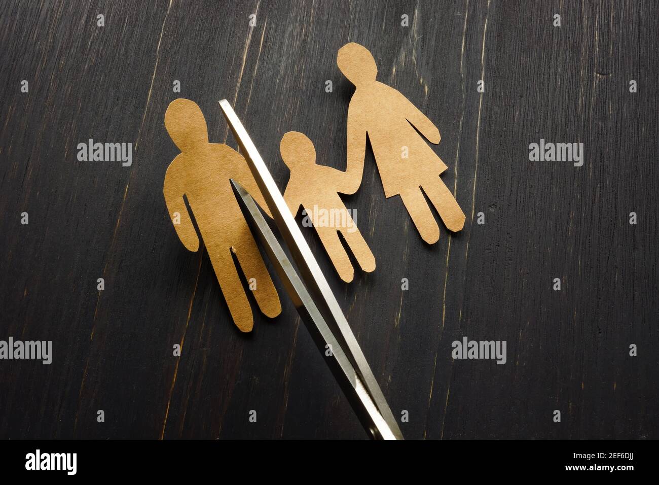 Concept de séparation et de divorce. Figurines de famille avec enfant et ciseaux. Banque D'Images