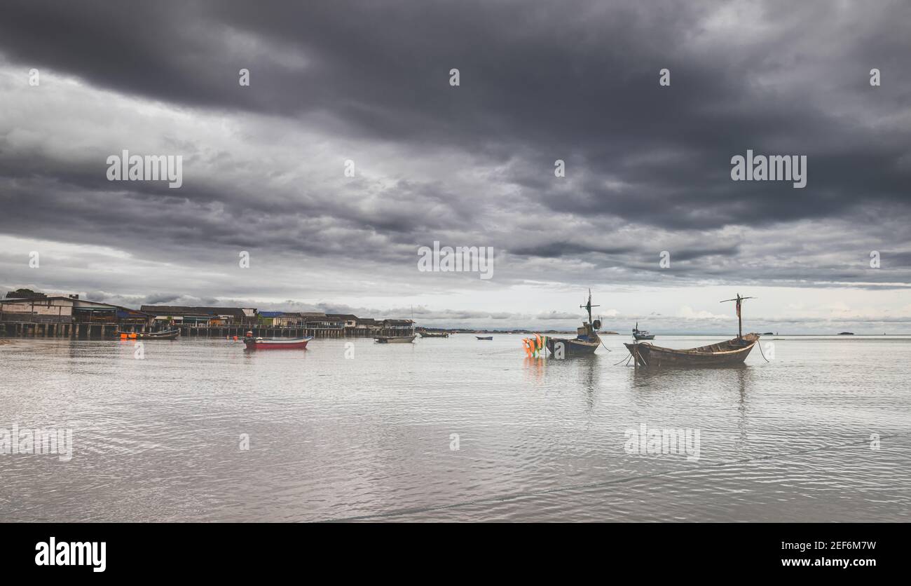 Bateaux de pêche en bois avec éclairage extérieur et ciel nuageux foncé. Banque D'Images