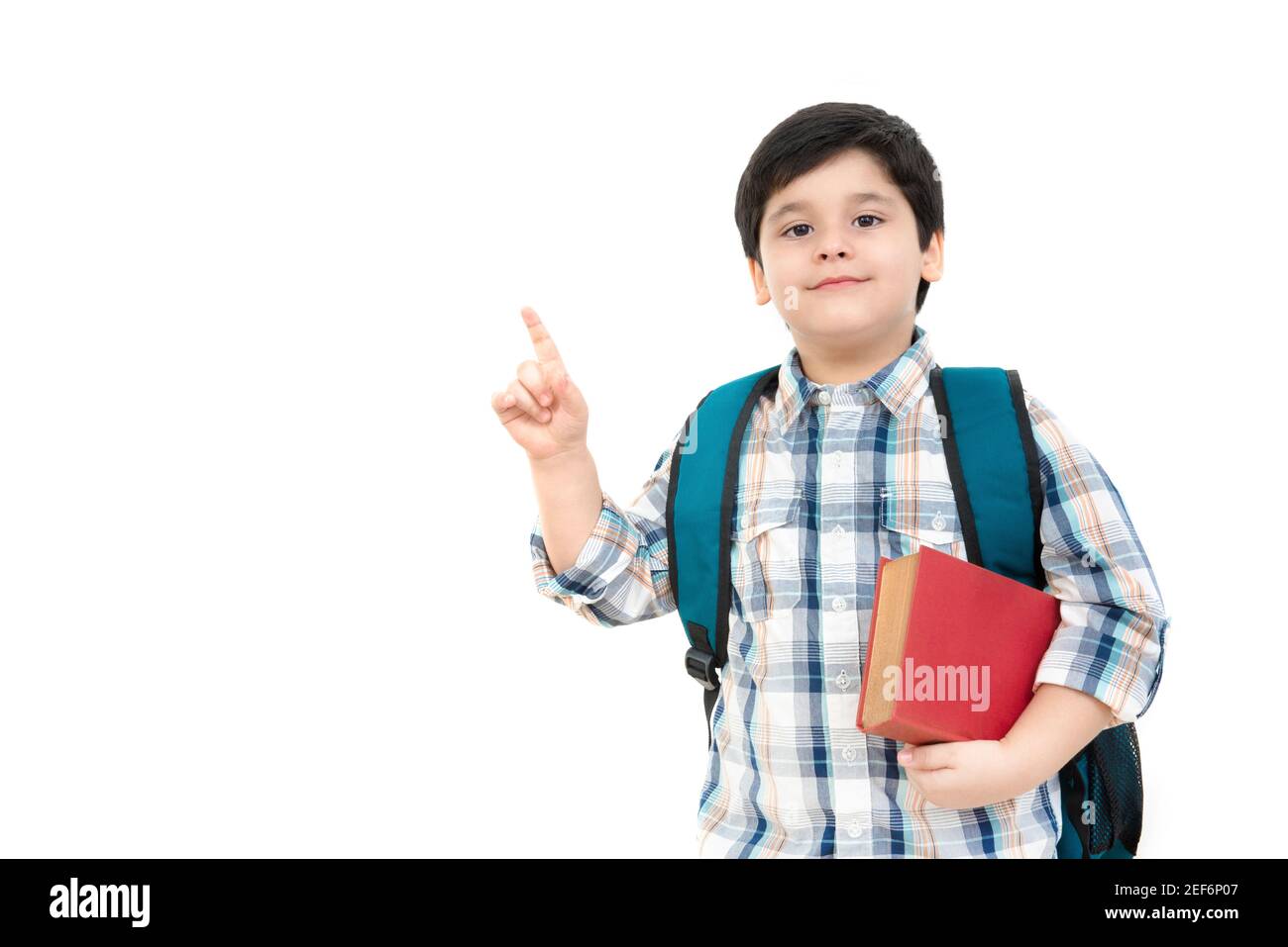 Joli petit garçon d'école pointant vers l'arrière vers l'espace vide aux concepts scolaires et éducatifs Banque D'Images