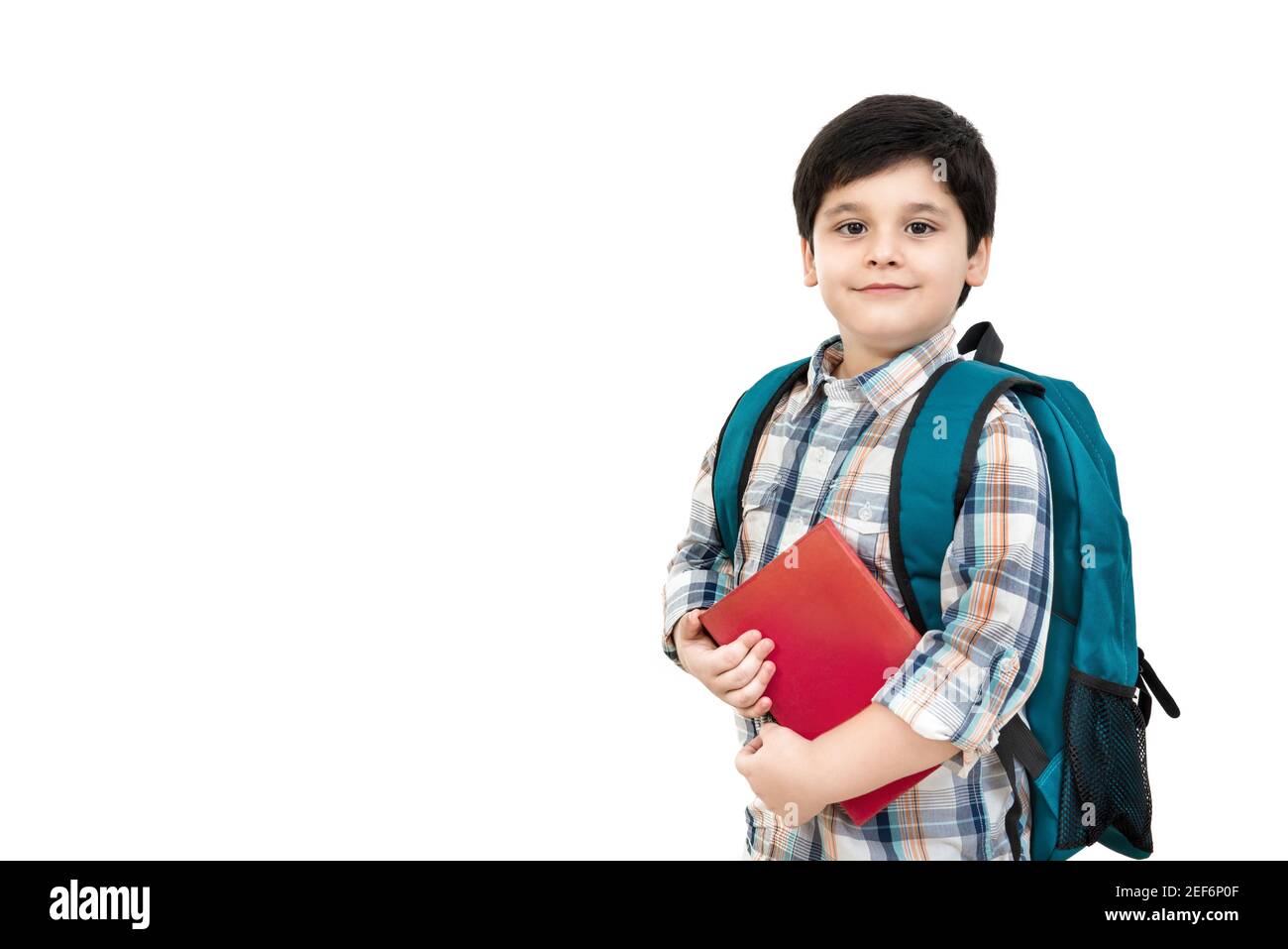 Adorable garçon asiatique portant un sac d'école et tenant un livre mains, isolé sur fond blanc avec espace de copie - arrière aux concepts scolaires et éducatifs Banque D'Images