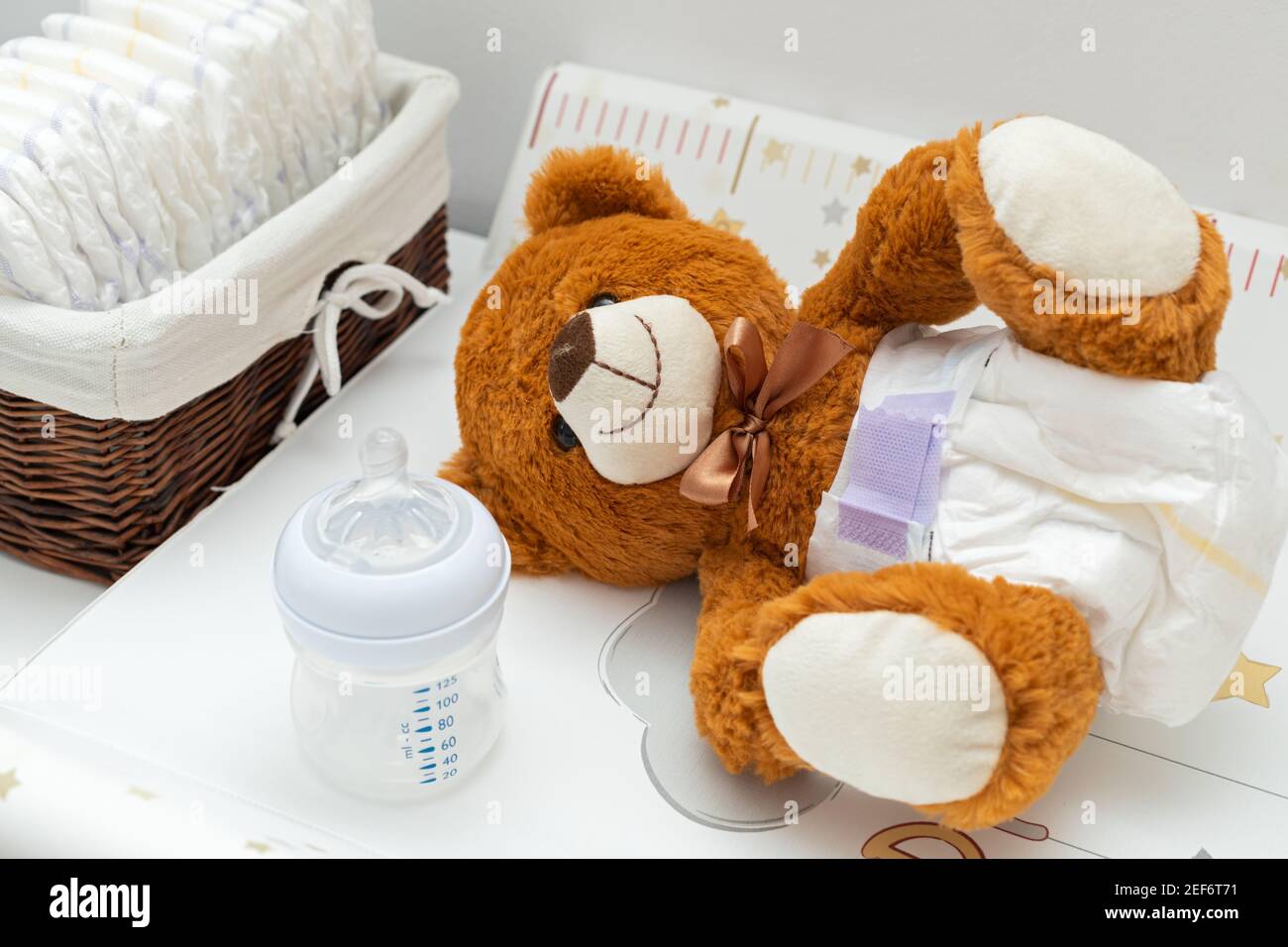 La peinture d'un ours en peluche brun avec couche sur la position assise  dans le lit de bébé Photo Stock - Alamy