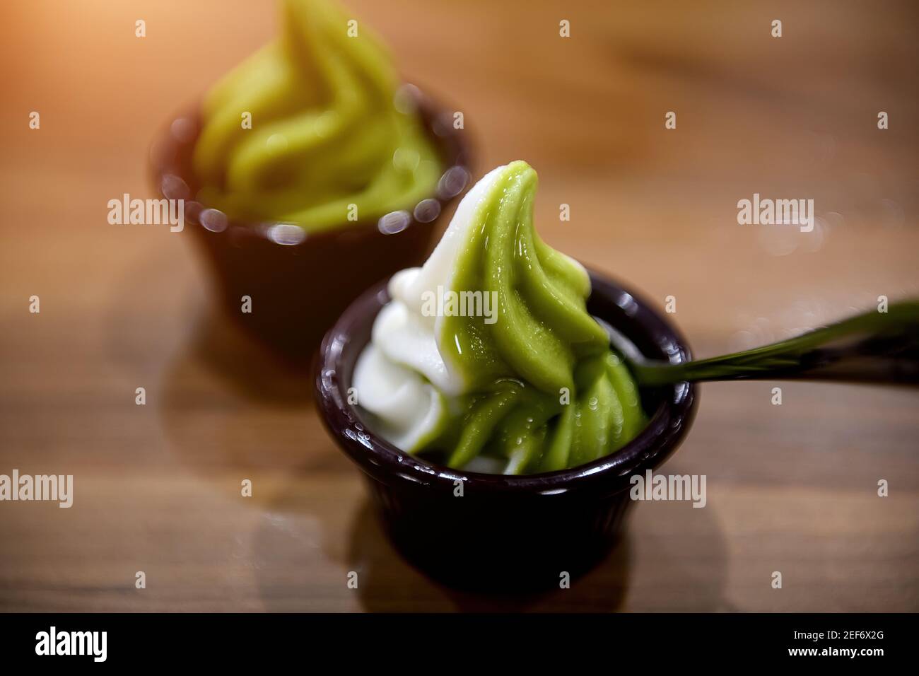 Glace au thé vert Matcha dans une tasse sur une table en bois à faible éclairage. Banque D'Images