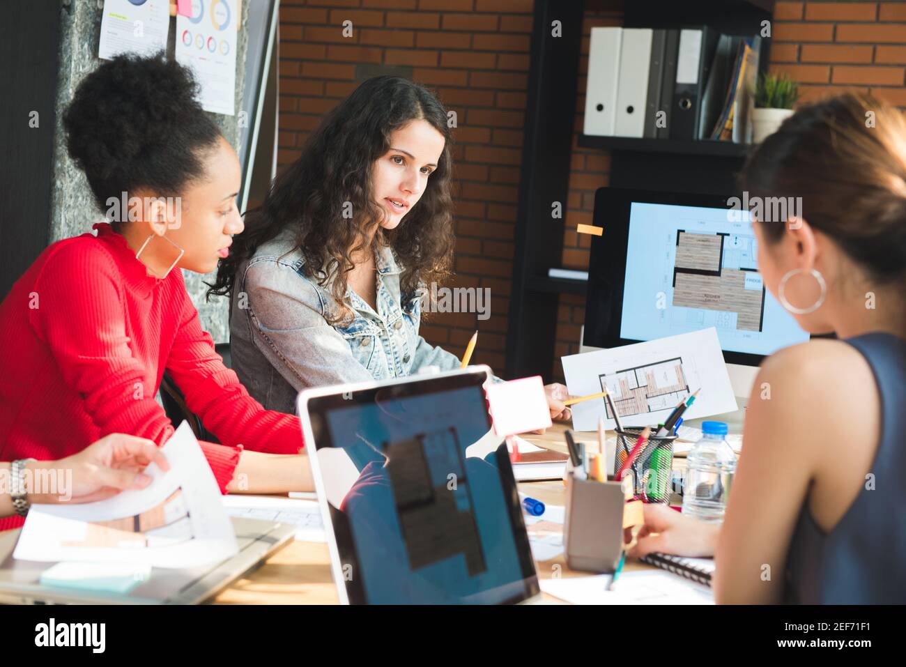 Jeune équipe créative féminine à caractère multiethnique lors de la réunion de entreprise de design d'intérieur - travail d'équipe et idées de brainstorming Banque D'Images