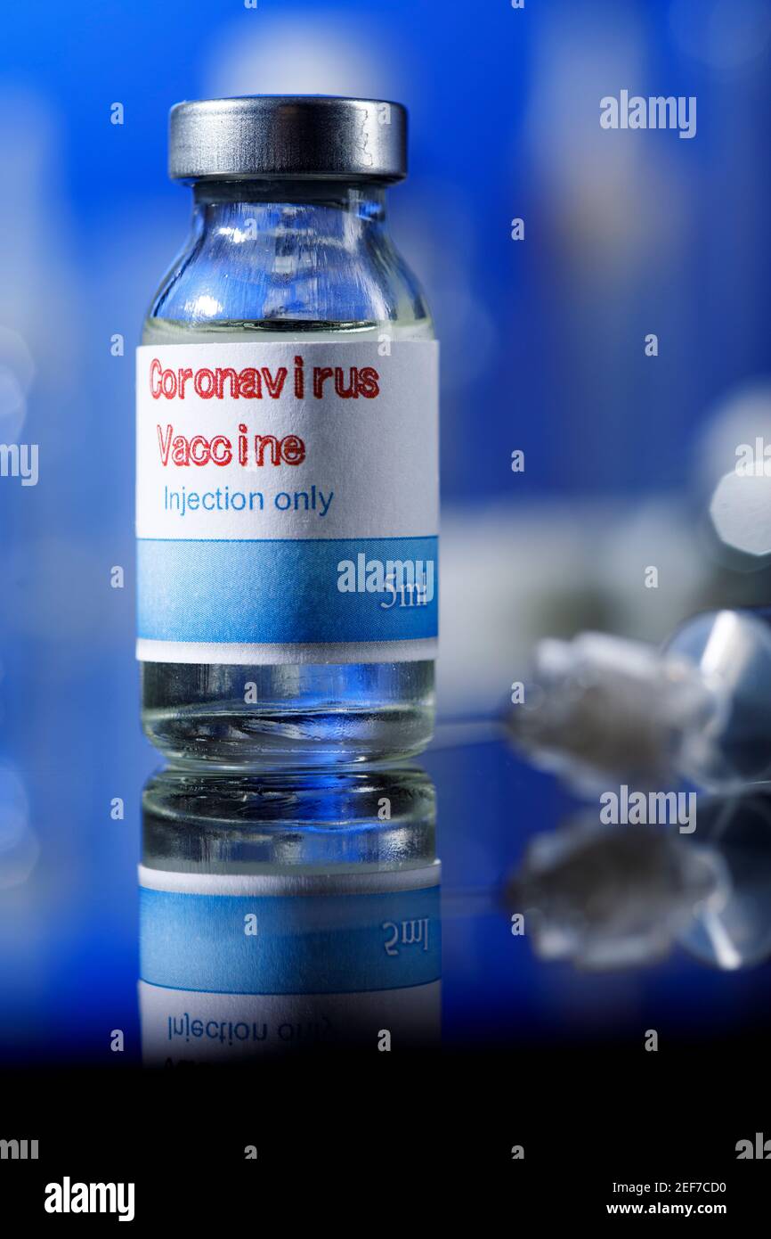 filet de verre de vaccin covid avec seringue et autres récipients de laboratoire placés sur une surface réfléchissante, isolés sur fond bleu Banque D'Images