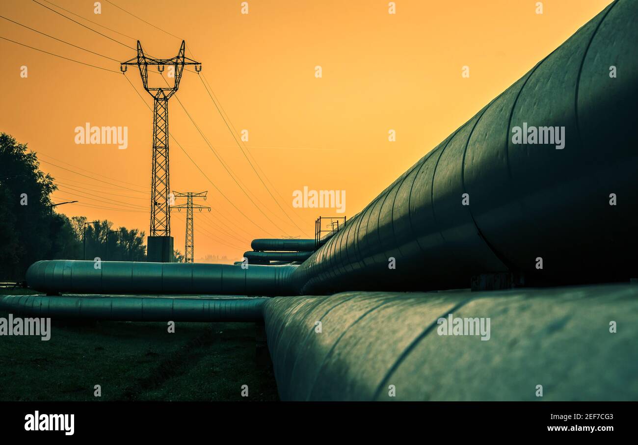 Fils électriques et tubes de chauffage urbain au lever du soleil Banque D'Images