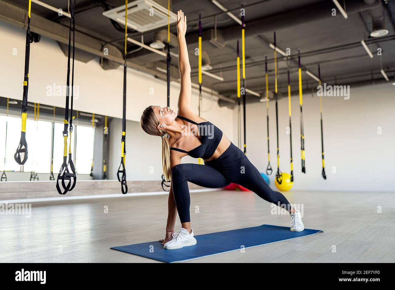 Jeune femme sportive pratiquant le yoga isolée sur fond blanc, concept de vie saine et équilibre naturel entre le corps et le développement mental. Banque D'Images