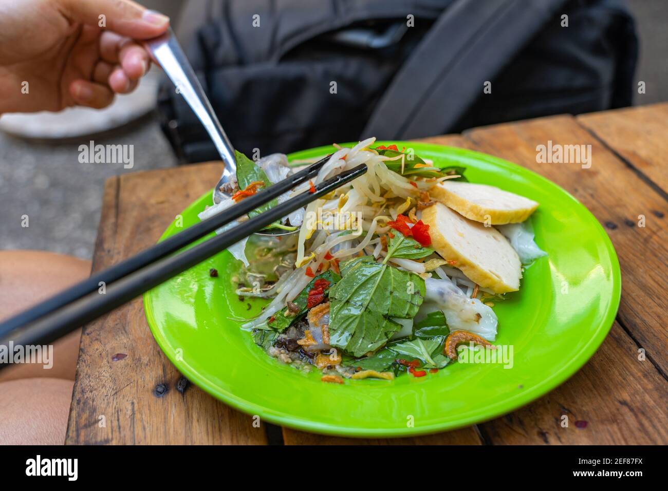 Photo en gros plan des rouleaux de riz vapeur du Vietnam mangeant des êtres humains par baguettes et cuillère Banque D'Images
