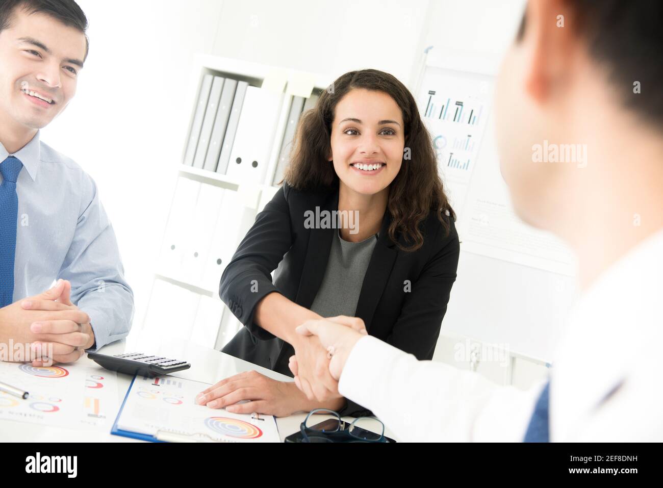 Femme d'affaires faisant poignée de main avec un homme d'affaires à la réunion Banque D'Images